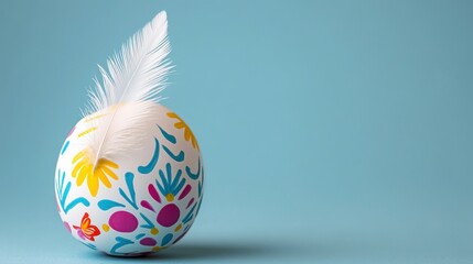 Fototapeta premium White Easter Egg with Colorful Floral Pattern and Feather on Light Blue Background
