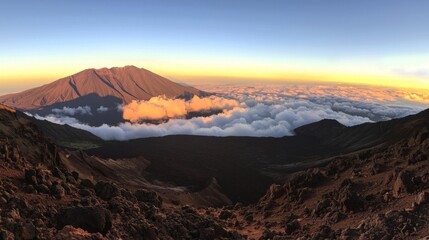 A breathtaking view from a mountaintop, clouds below glowing with the morning sun. 
