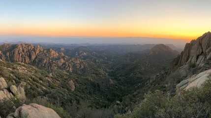 Fototapeta premium A hiker enjoying a panoramic sunrise view from a rugged mountain summit. 
