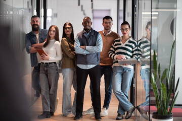 Obraz premium A diverse, multiethnic business team of entrepreneurs and leaders in a modern office, collaborating in an open space. Their teamwork, motivation, and partnership fuel the company's growth and success