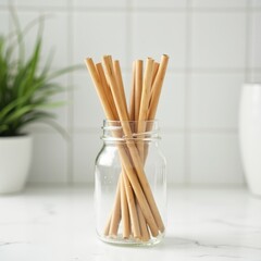 Bamboo straws in glass jar on white countertop