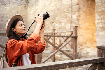 photographer tourist traveler using camera taking photos of landmark in medieval fortress,...