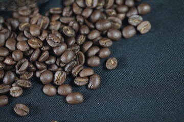 Roasted Coffee Beans Close-up: Aromatic roasted coffee beans cascade over a textured surface, inviting the rich flavors. Photorealistic texture and a warm inviting tone.