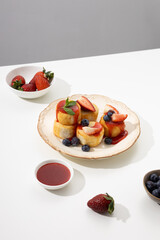 Syrniki with strawberries on plate breakfast dish light table