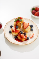 Syrniki with strawberries syrup on plate breakfast dish light table