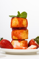 Stack of  cheese fritters with strawberries syrup breakfast dish light table
