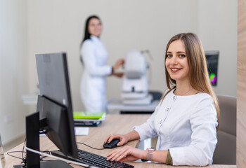 Pro optometry office at work. Two specialists work in an optometry office, one assisting a patient...