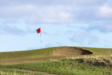 A red flag is flying on a golf course. Dunbar, Scotland