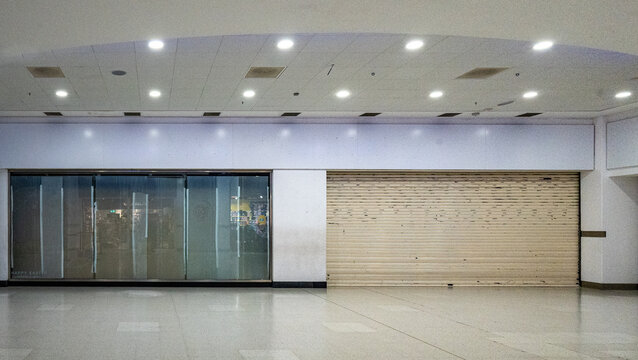 A shop that has closed down and is shuttered up in a shopping mall depicting the downturn in the British economy.
