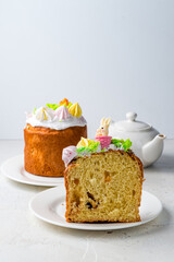 Tasty Glazed Easter cake with rabbits and spring flower on white kitchen table, copy space
