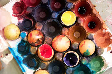 top view of a colored pallet with dyed Easter eggs with natural dyes