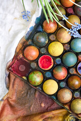 top view of a colored pallet with dyed Easter eggs with natural dyes