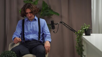 A young man recording a podcast or expert video in a professional studio.