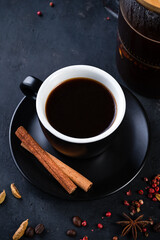 coffee with anise, cinnamon and cardamom on a dark background