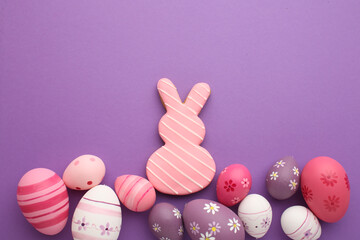 Fototapeta premium Easter holiday. Festive composition. Food decor. Homemade ornament. Creative colorful arrangement of painted pink blue yellow eggs with cute bunny chicken pattern isolated on light pastel background.