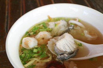 Closeup of Seafood Rice Porridge with Mouthwatering Seabass in a Spoon
