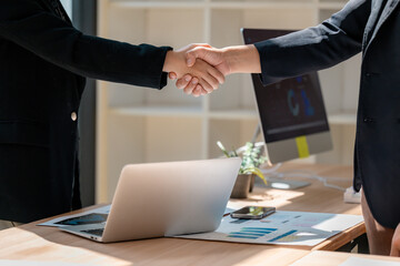 Business partners shaking hands after meeting in office