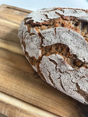 Photo with closeup view  of delicious homemade sourdough bread, freshly baked and on wooden board. The natural, organic home baked loaf. Healthy cooking and lifestyle.