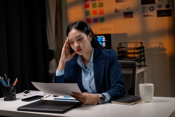 Businesswoman having headache after reading accounting report and working late in office