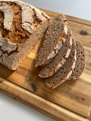 Photo of delicious homemade sourdough bread, freshly baked and sliced, with fluffy crumb and golden crust. The natural, organic home baked loaf. Healthy cooking and lifestyle.