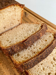 Photo of cutting homemade white wheat bread in a extreme closeup. Crusty natural fresh soft sourdough with firm crust. Traditional cooking and home backing concept.