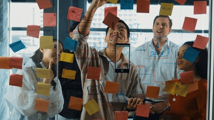 Portrait of professional business team brainstorming marketing idea by using sticky notes to share...
