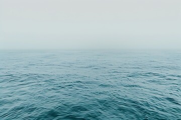 Fototapeta premium a calm ocean surface with water waves against clear blue sky