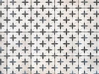Close up of black and white star floral shape heritage and colonial tiles pattern. Retro colonial floor tiles in diamond and random geometrical plus and cross texture. Seamless background.