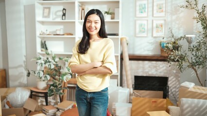 Entrepreneur crossing her arm as ownership while standing at home office. Happy female seller looking at camera with confidence while standing with folded arm at small business or start up. Myrmidon.