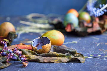 colored pallet with Easter eggs painted with natural dyes stands on a dark blue background, top view