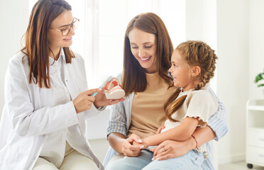 Mother and girl attend an appointment with a dentist doctor or nurse to learn about tooth cleaning....