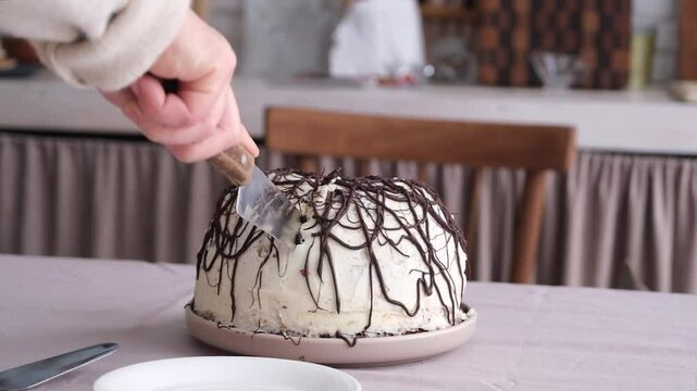 unrecognizable woman cutting Pancho cake in the kitchen