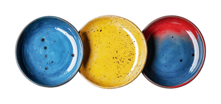 Vibrant set of three handmade ceramic bowls in blue, yellow, and red for artistic table settings and decorative purposes, cut out