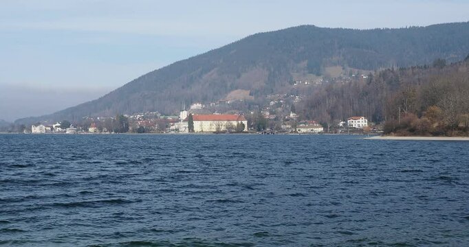View of the eastern shore of Lake Tegernsee, the castle and the brewery at the foot of the hills and wooded massifs