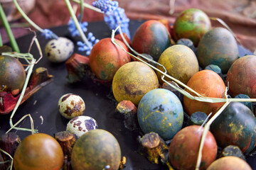 colored dark pallet with eggs for Easter stands on a black board on a table, top view
