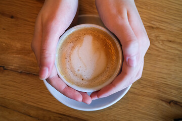 Hands around a cup of coffee