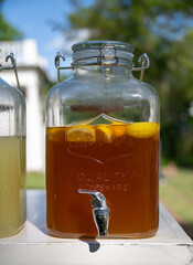 Tea With Floating Lemon in Glass Serving Jar