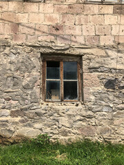 Old window in an old house made of wooden frame and old glass in the village in summer