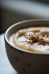 Close-up view of creamy homemade organic applesauce with cinnamon on light countertop