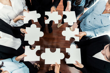 Top view multiethnic business people holding jigsaw pieces and merge them together as effective solution solving teamwork, shared vision and common goal combining diverse talent. Meticulous