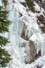 Frozen waterfall, Icicles on a rock face in the mountains. Dolomites, Italy, Europe in wintertime.