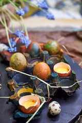 colored dark pallet with eggs for Easter stands on a black board on a table, top view