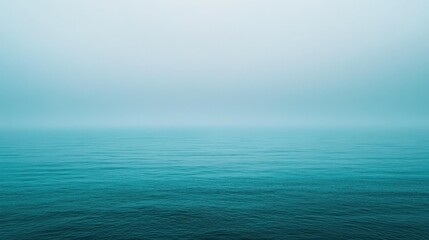 Obraz premium A tranquil ocean scene with misty horizon over the water