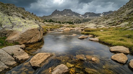A Stream Flows Through Rugged Mountains Under Cloudy Skies