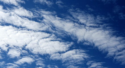 Fototapeta premium Dramatic sky with wispy white clouds on a blue backdrop