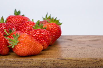 Strawberries on a wooden board, on white background.