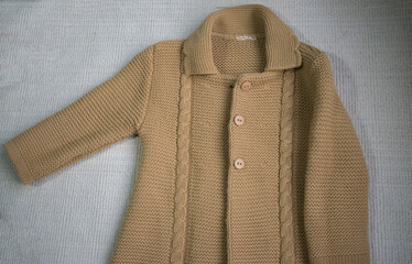 knitted baby sweater on white background