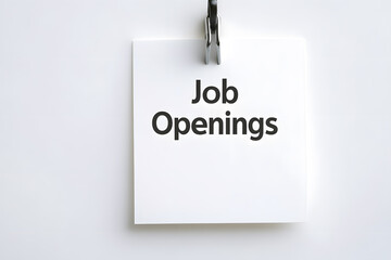 White square paper attached to a wall with a metal clip, announcing job openings in bold black text on a white backdrop. Minimalist recruitment notice.