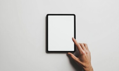 A person is pointing at a tablet with a white screen
