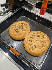 Close up of fresh focaccia bread with salt and rosemary top view just baked